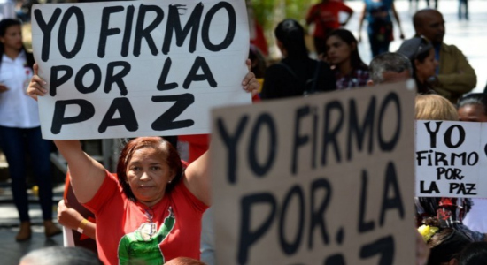 Mujer sostiene una pancarta en favor del chavismo