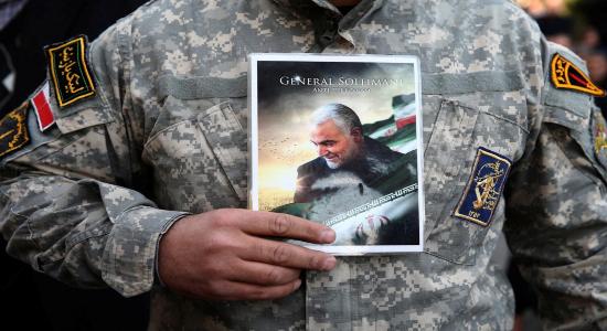 Soldado sostiene foto de Soleimani