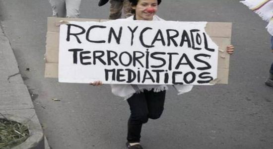 Manifestante sostiene pancarta contra RCN y Caracol