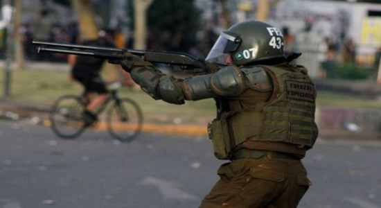 Carabinero apuntando arma | Foto: Desconcierto