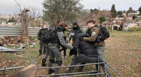 La Policía israelí expulsa a un hombre de la zona en la que estaba la casa de los Salhiya, ahora reducida a escombros. (Ahmad GHARABLI | AFP)